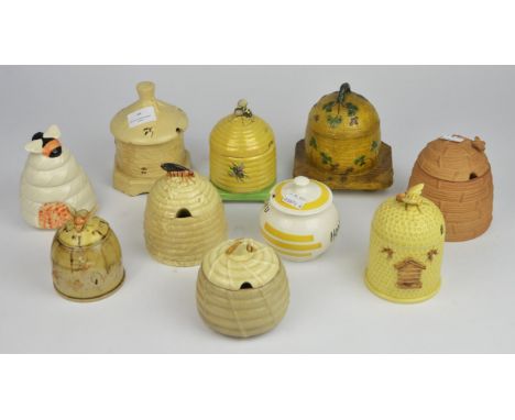 A Carltonware yellow lustre glazed honey pot and cover together with sixteen other honey pots (17)