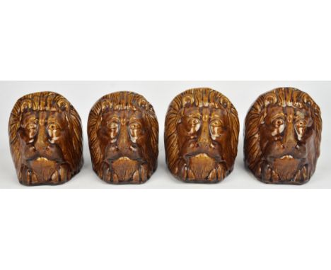 A set of four Victorian Staffordshire stoneware, sash window door stops, each moulded with lion heads, 11cm high.  (4)