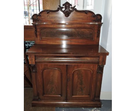 A Victorian mahogany chiffonier, the carved raised shelf back over frieze drawer and panelled cupboards, W. 107cm.