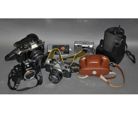 A Nikon EM 35mm camera body, together with a Konica FT1 35mm camera, and five other cameras. (7)