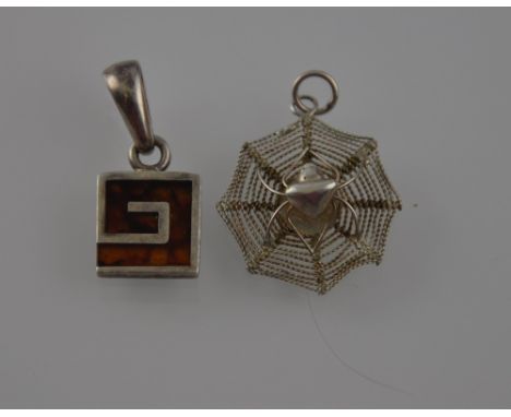 A white metal pendant in the form of a spider on it's web, stamped 925, together with another white metal an enamel pendant, 