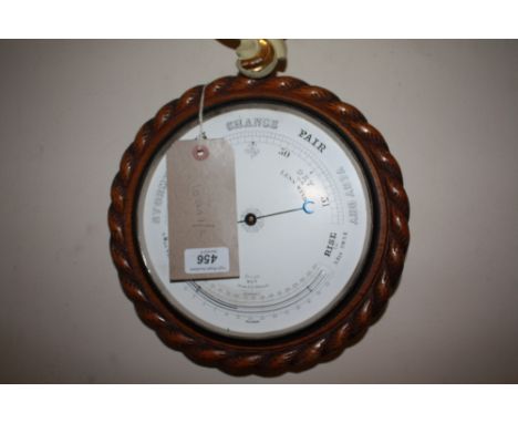 An early 20th Century oak aneroid barometer with carved ropetwist case.