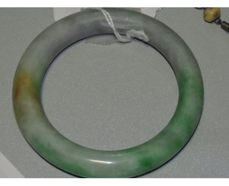 An antique jade bangle, incorporating three colours: lavender, honey and green.