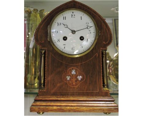 An Edwardian oak-faced mantle clock in the Arts & Crafts style, the white enamel dial set our in Arabic numerals above column