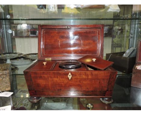 A Victorian mahogany three section tea caddy of sarcophagus form, with mixing bowl and ivory handles to caddy lids and escutc