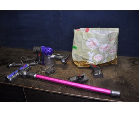 A DYSON DC34 ANIMAL HANDHELD CORDLESS VACUUM CLEANER with two attachments and charger (PAT pass and working), two fitting tha