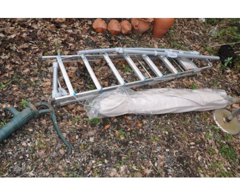 A GARDEN PARASOL WITH WIND AND TILT MECHANISM approx. 280cm across, an aluminium step ladder and a vintage cast iron water pu