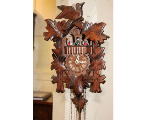 A German black forest cuckoo clock, carved with oak leaves and a bird, with four musical rotating figures and three weights