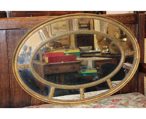 A modern reproduction oval wall mirror with gilt surround 87.5cm