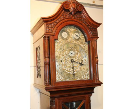 An early 20th century mahogany longcase clock, the ornate domed 10 1/2 inch dial with Arabic numerals, three subsidiary dials