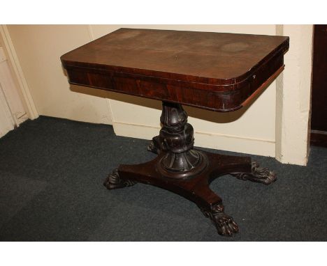 An early 19th century rosewood card table, with shaped rectangular top and carved baluster stem, on raised platform base, lio