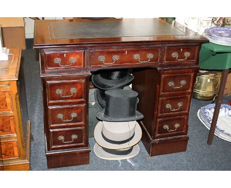 A reproduction mahogany pedestal desk, with leather inset rectangular top over an arrangement of nine drawers, on bracket bas