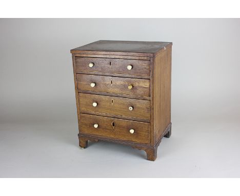 A miniature mahogany chest with four drawers and bracket feet, height 28cm