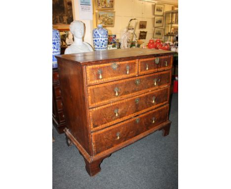 A continental fruitwood chest of two short over three long banded drawers, with brass drop handles, on shaped bracket feet, 9