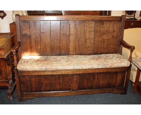 An oak box seat settle, with open arms, on bracket base, 158cm