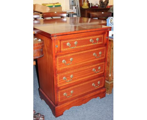 A reproduction inlaid mahogany chest of four drawers, with brass drop handles, beneath drop flap enclosing leather inset writ