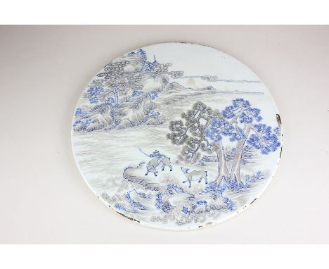 A circular Chinese ceramic plaque, decorated in blue and red with a figure and two oxen amidst mountainous landscape, 27.5cm 
