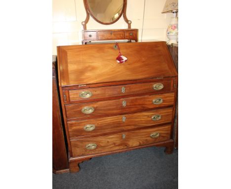 A George III mahogany bureau with fitted interior of small shelves and pigeon holes, above four graduated drawers with brass 