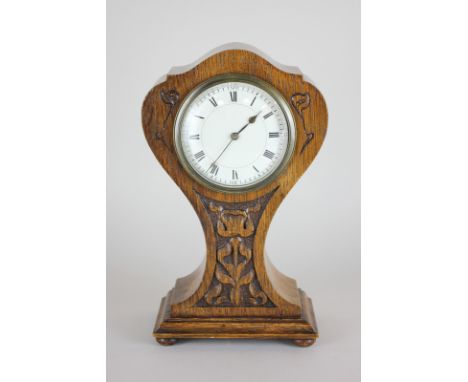 An Art Nouveau style carved oak mantle clock, the waisted form with carved floral design and bevelled glass over Roman numera