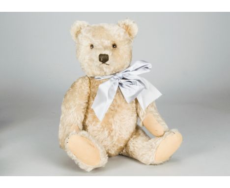 A post-war Steiff teddy bear,  with beige mohair, brown and black glass eyes, brown stitched nose, mouth and claws, swivel he