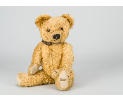 A post-war Merrythought teddy bear,  with dark golden mohair, orange and black glass eyes, pronounced muzzle, black stitched,