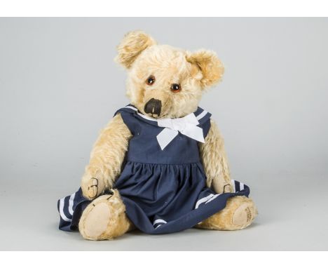 A post-war Merrythought teddy bear,  with golden mohair, orange and black glass eyes, pronounced muzzle, black stitched nose,