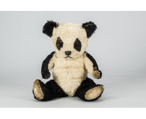 A post-war Chiltern panda,  with black and white mohair, orange and black glass eyes, black stitched nose, mouth and claws, s