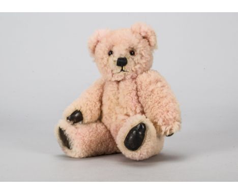 An early post-war Farnell pink sheepskin teddy bear,  with orange and black glass eyes, black stitched nose and mouth, swivel