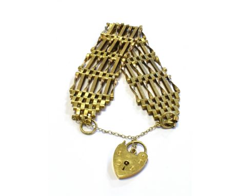 9CT GOLD GATE BRACELET 23.6mm wide with 7 bars, a heart shaped padlock clasp and safety chain attached.  Hallmarked 375 Londo