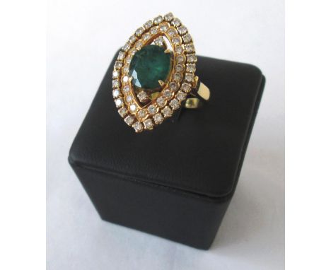 EMERALD AND DIAMOND DRESS RING oval cut emerald bordered by brilliant cut diamonds on a pierced navette setting, ring size 4/