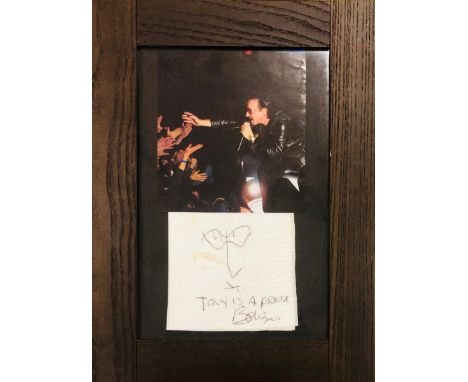 U2. A mounted and framed display to include an original sketch on a napkin with inscription 'Tony is a prince' with signature