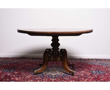 A 19th century rosewood tilt-top centre tableThe top with beaded edge, raised on a turned and beaded stem over four scroll su