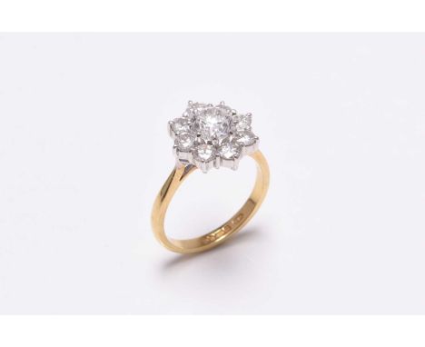 An 18ct gold diamond floral cluster ring, designed as a central round brilliant cut diamond, claw set in white gold within a 