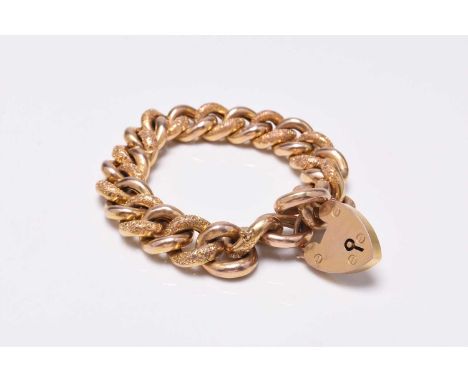 A yellow metal curb link bracelet, formed of alternating polished and textured hollow links with heart shaped padlock clasp, 