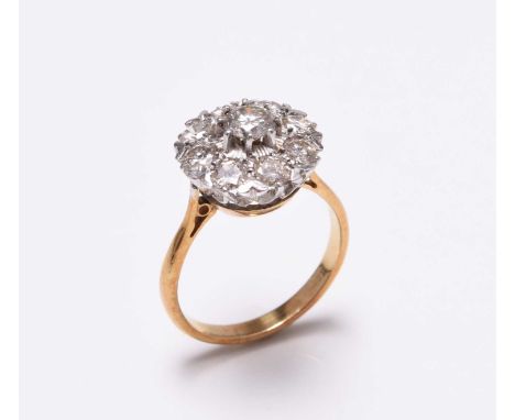 A diamond floral cluster ring, designed as a central brilliant cut diamond, claw set in white metal within a border of eight 