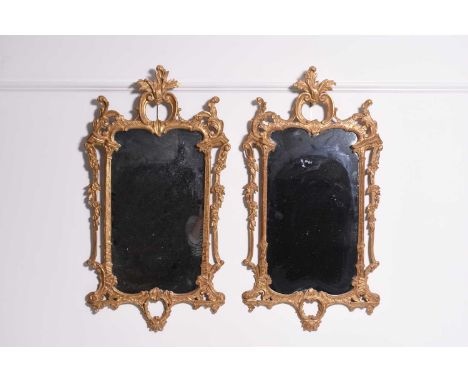 A pair of rococo revival giltwood wall mirrorsThe rectangular plates framed by architectural pilasters surrounded by scrollin