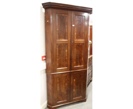 A George III figured mahogany and banded corner cupboard enclosed four panel doors, on bracket feet, 42" wide