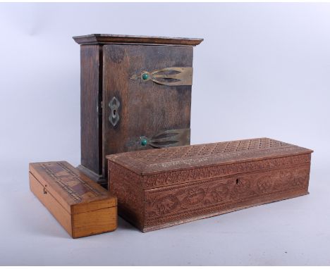 A marquetry work cribbage board, 10 1/2" long, a chip carved glovebox, 16" long, and an oak cupboard with brass strap hinges,
