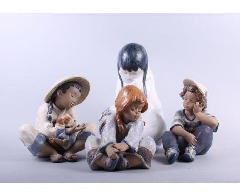 Four Lladro figures, two figures of children, Oriental girl with puppy and child wrapped in a rug