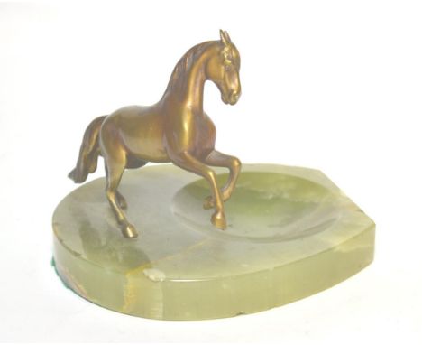 An onyx ashtray mounted with a patinated model of a horse 