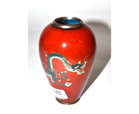 An cloisonne enamel vase decorated with a dragon curled around a red background 