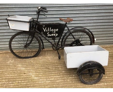 A tradesman's bicycle with side car attachment, Village Sweep sign set within the frame and a basket to the front. 