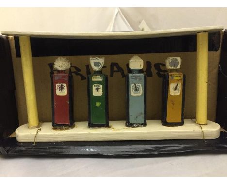 A set of four Britains petrol pumps on a painted wooden island, Shell, BP, Dominion and National Benzole. 