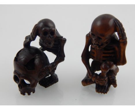 Two Japanese hardwood and boxwood netsuke modelled as human skeleton, one leaning on an ancient skull and bears signature dis