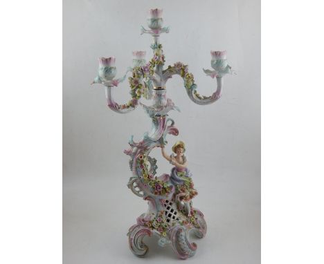 A Continental four light, three branch candleabra, decorated with encrusted flowers and maiden, raised on scrolling gilt heig