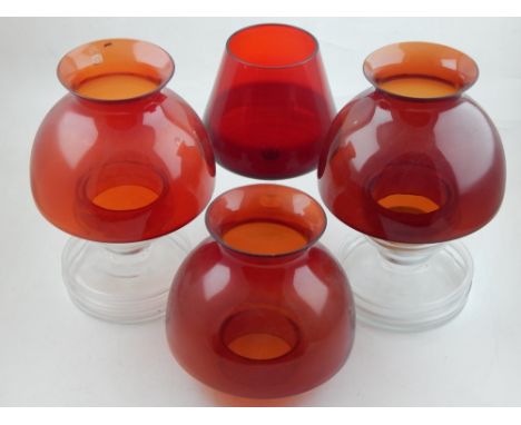A pair of glass tea light holders, with red shades and clear glass bodies, together with an addition shade, and a glass. H. 2