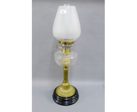 Brass oil lamp with glass well, ebonised base and opaque shade, 68cm high overall