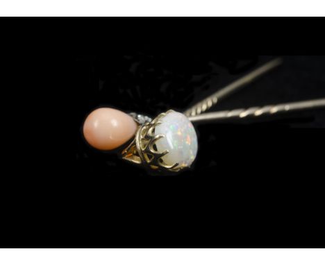 An early 20th Century diamond and coral stick pin, the pink pear shaped coral bead surmounted in a mixed cut diamond petal mo