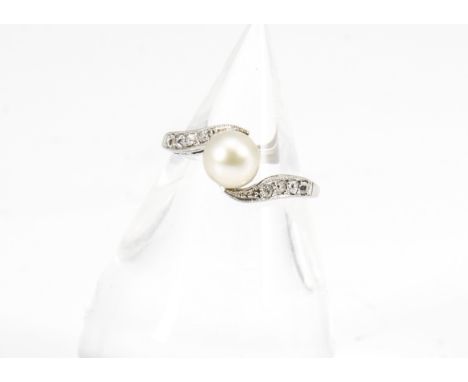 An art deco platinum pearl and diamond crossover ring, the pearl centre within a scroll setting with old cut diamonds marked 