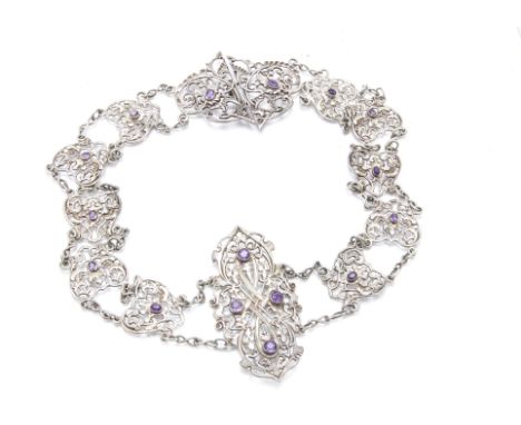 An Art Nouveau silver belt by SJ, the pierced scrolling foliage panels each with set with an amethyst and the larger central 